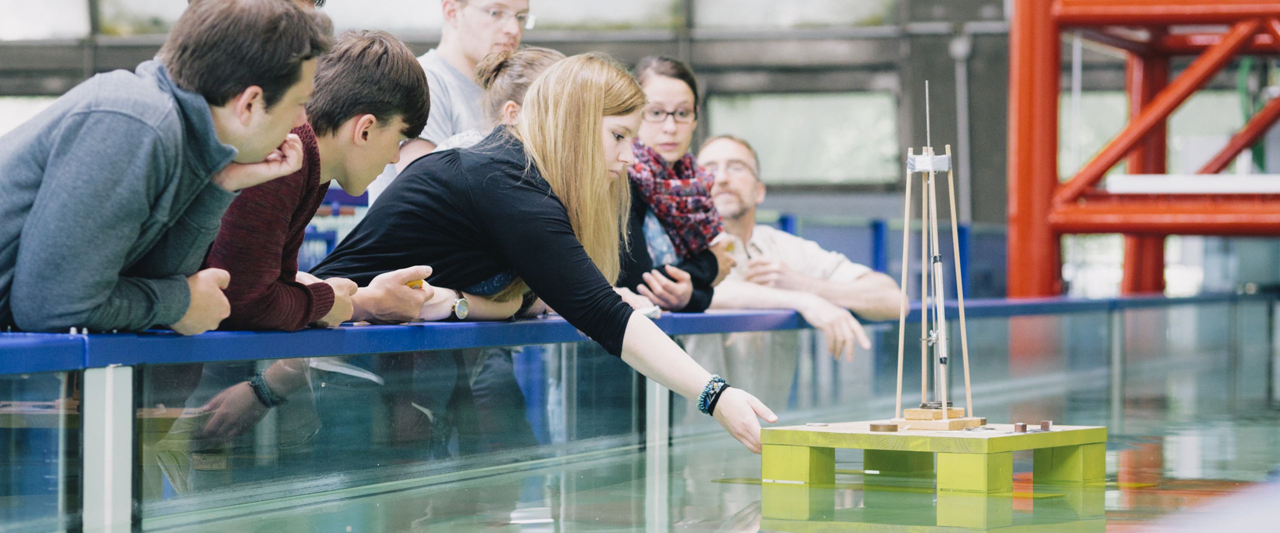 Studierende am Strömungskanal Studierende testen eine schwimmende Konstruktion in einem Wasserbecken.