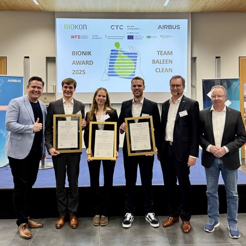 Bionik-Award 2025 Gruppenbild mit Männern und Frau. Drei Personen halten eine gerahmte Urkunde.