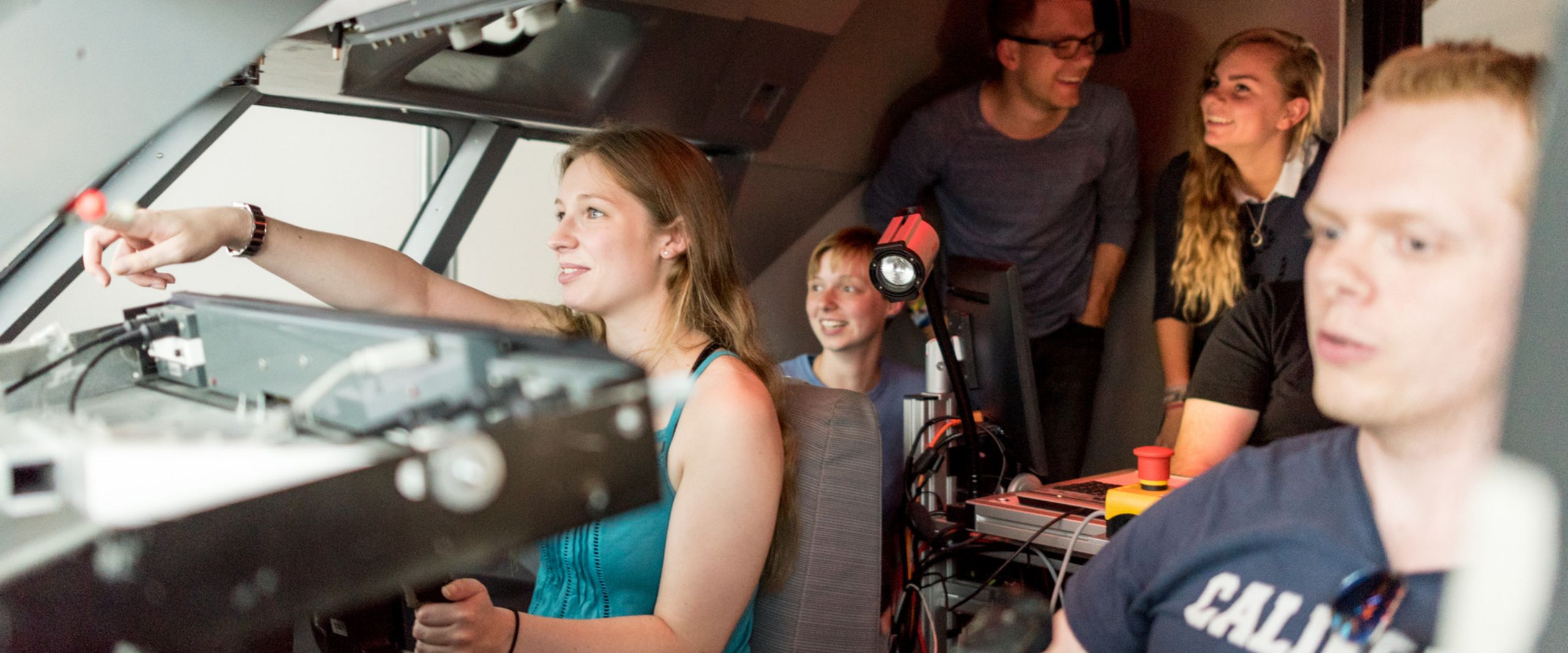 Flugsimulator Eine Gruppe Studierender sitzt im Cockpit eines Flugsimulators.