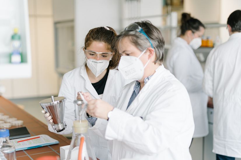 Hygienepraktikum Umwelttechnik  Laborleiterin erklärt einer Studierenden den Vorgang einer Filtration.
