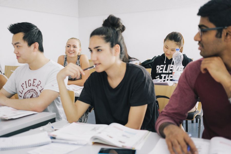Internationale Studierende Eine Gruppe Studierender sitzt an Tischen in einem Seminarraum.