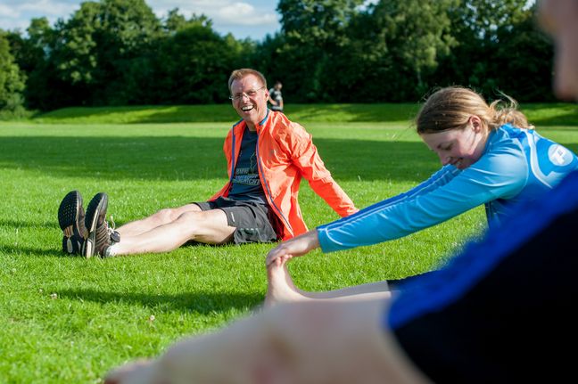 RS4901__DSC654220170704-scr.jpg  Trainer und Studierende beim Stretchen auf dem Sportplatz