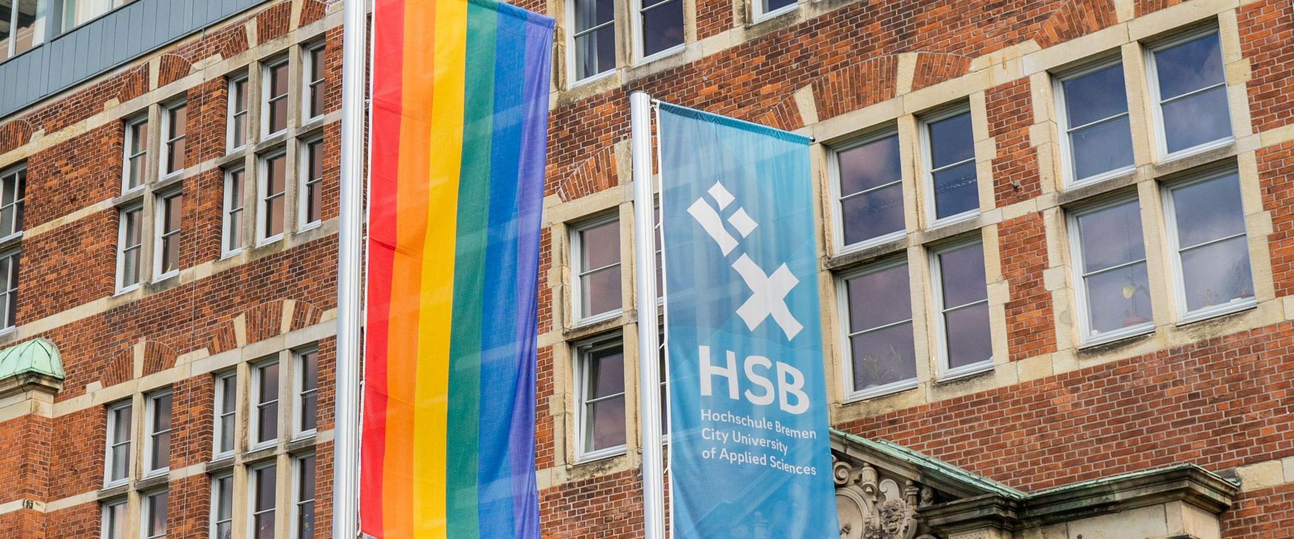 Eine Regenbogenflagge neben der HSB-Flagge.