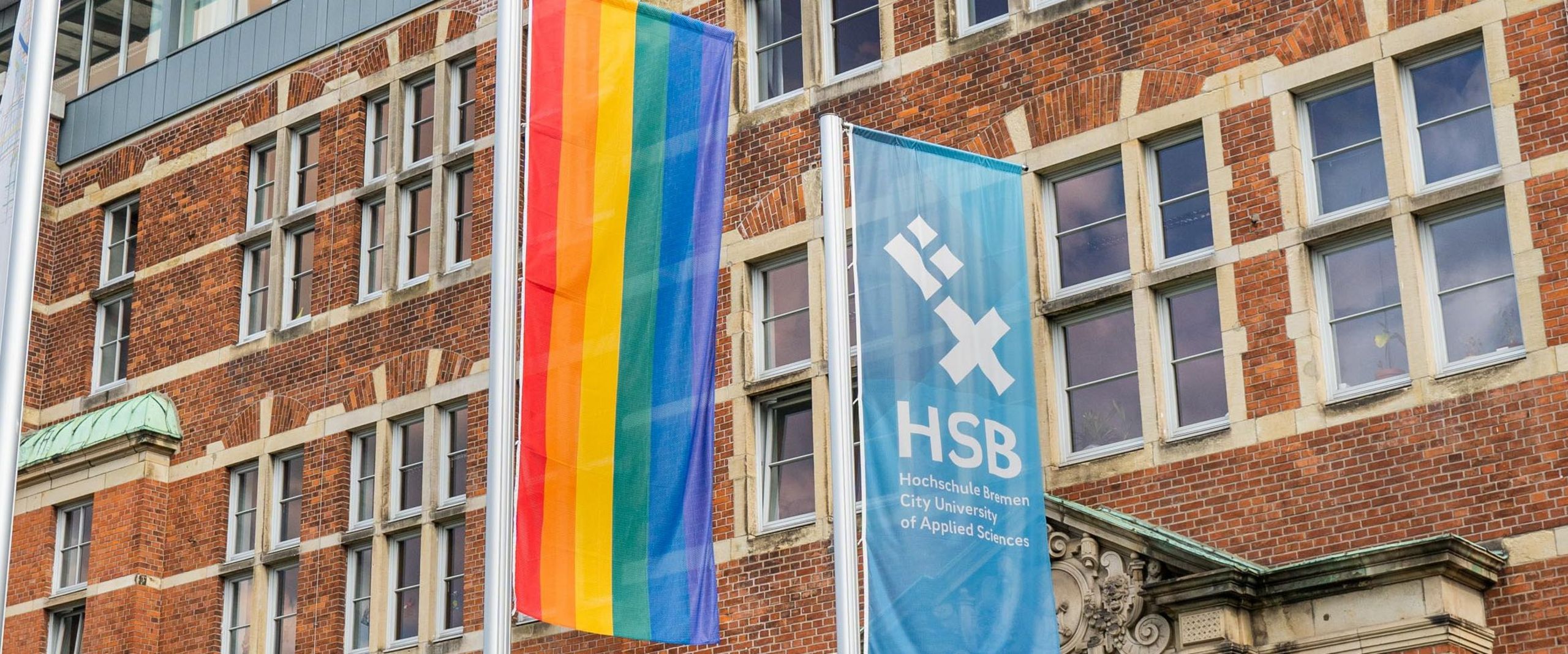 Eine Regenbogenflagge neben der HSB-Flagge.