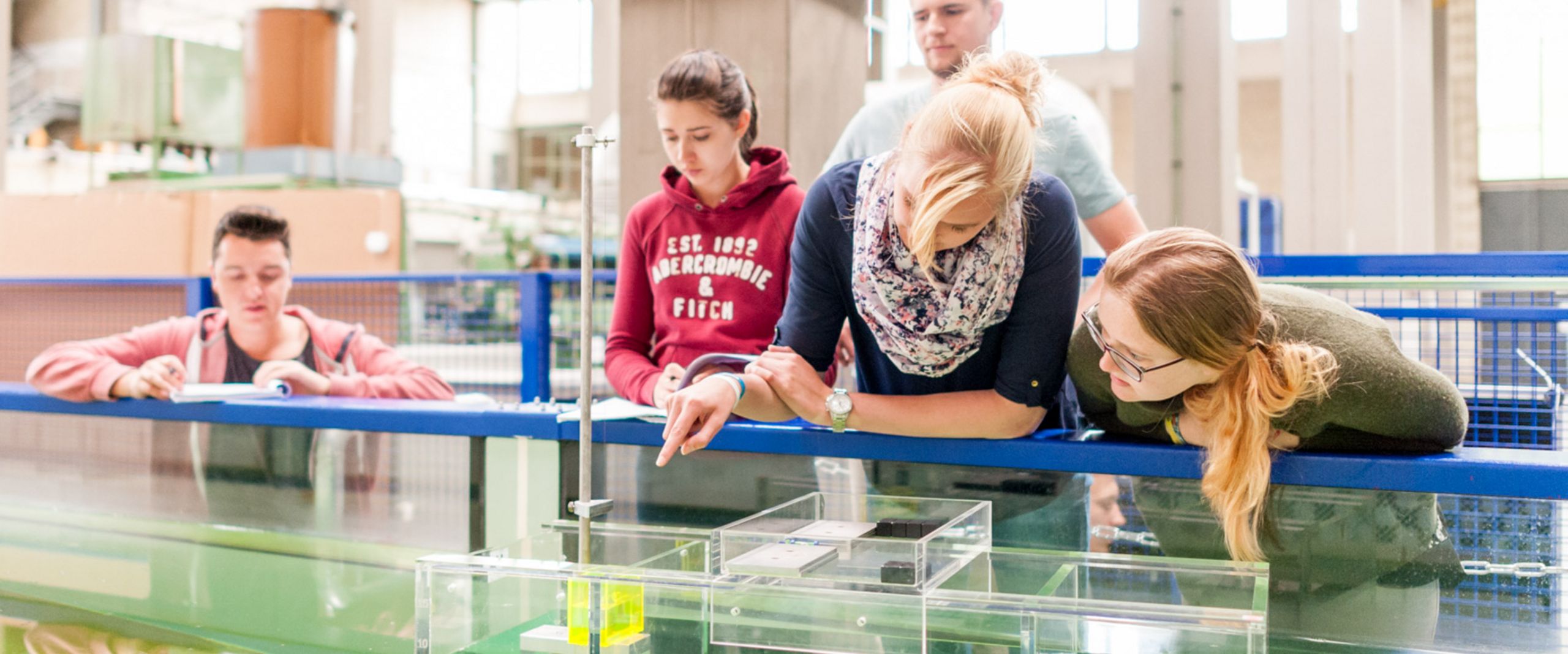 Studierende am Strömungskanal Studierende testen eine schwimmende Konstruktion in einem Wasserbecken.