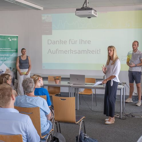 Learners Company 2025 Studierende stehen neben Professorin Renate Freericks. Neben Ihnen steht ein Beamer und ein Roll-Up.