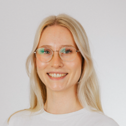 Junge Frau mit langem blonden Haar und goldfarbener Brille