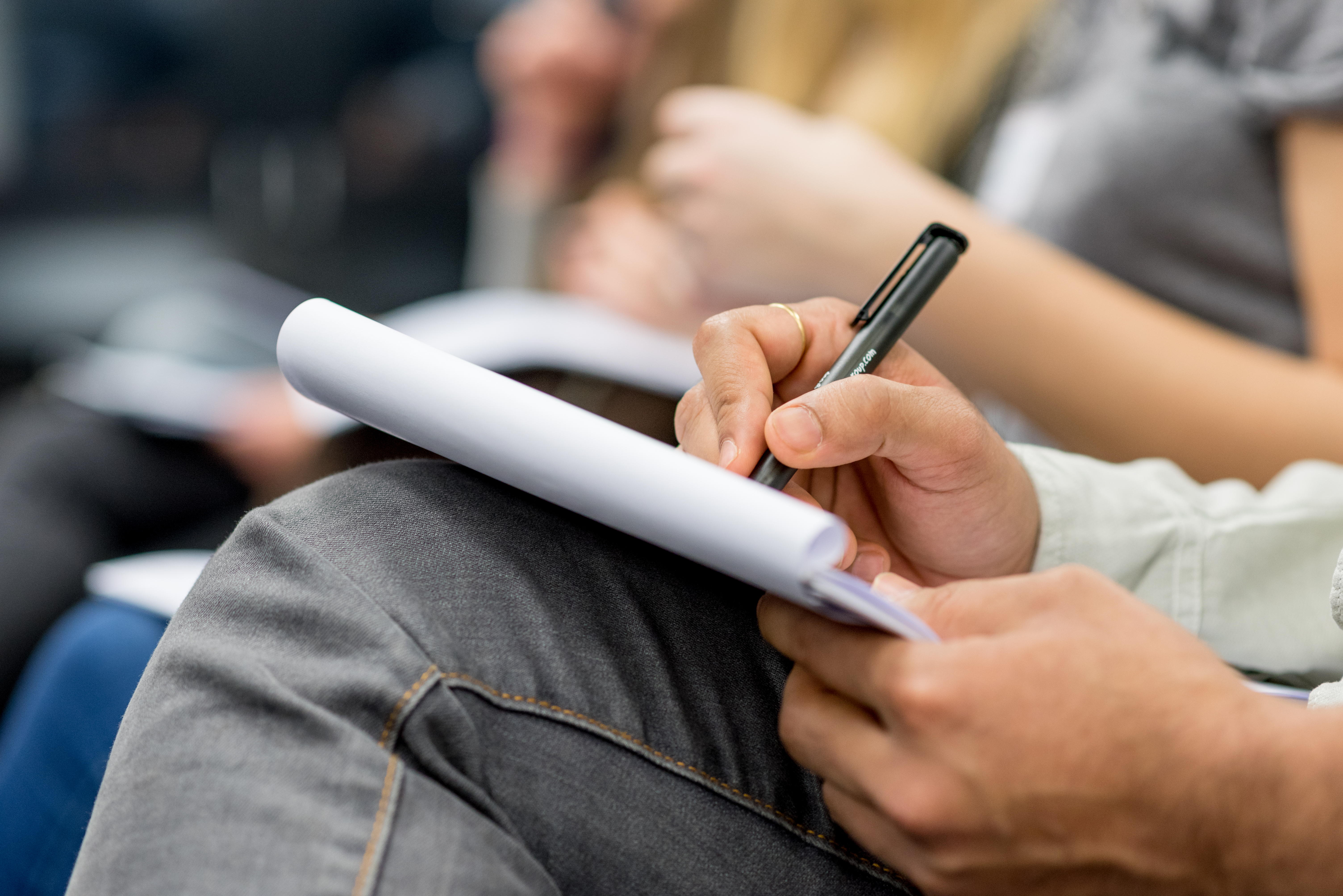Visum beantragen Bild zeigt jemanden, der auf Schreibblock schreibt