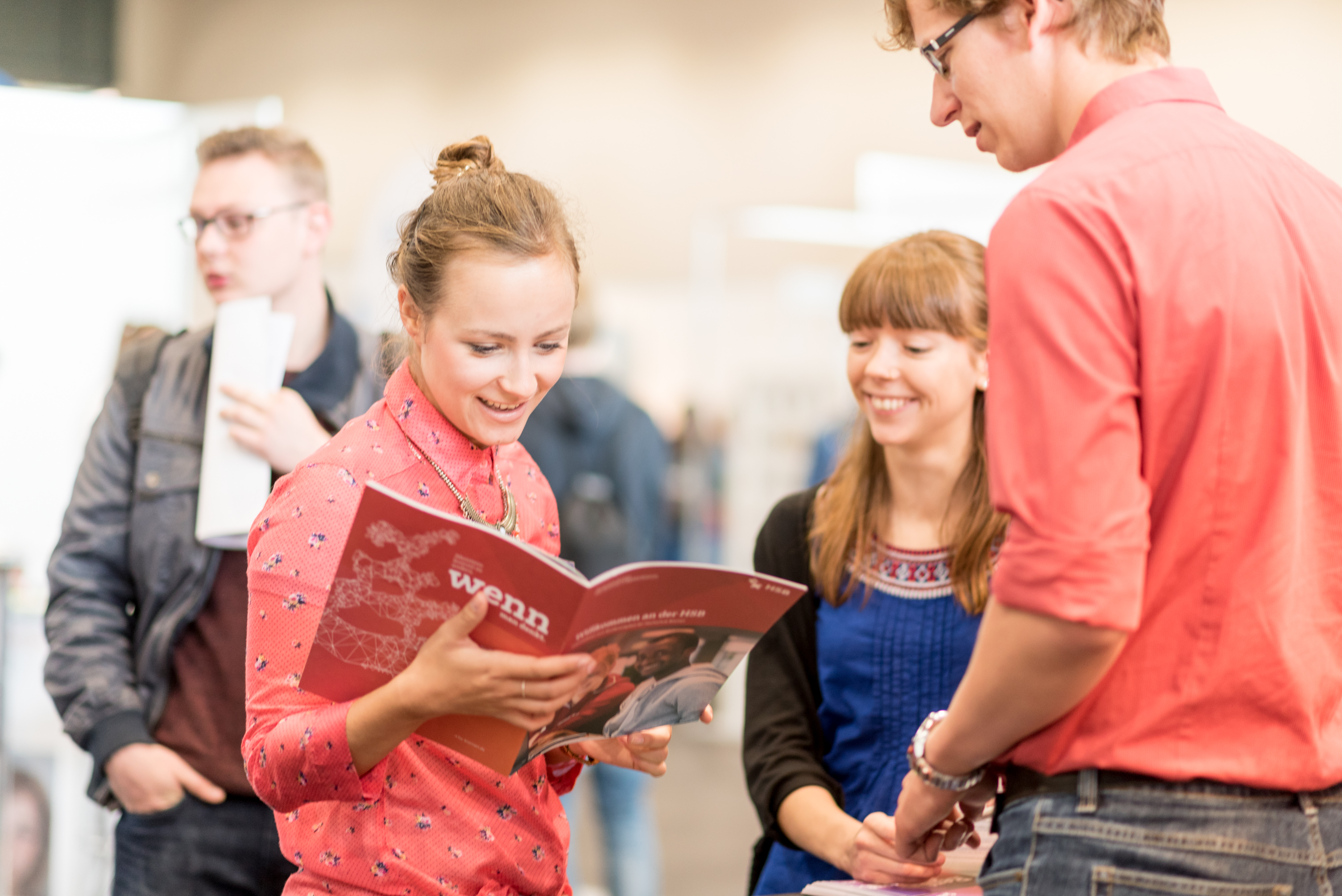 Junge Menschen im Gespr&auml;ch. Eine Frau schaut in eine Brosch&uuml;re.