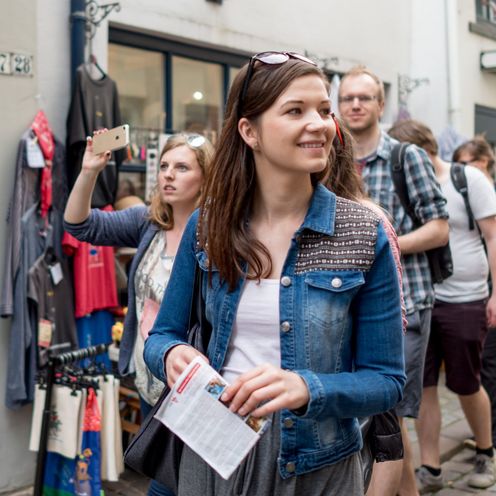 Junge M&auml;nner und Frauen laufen durch die Stadt