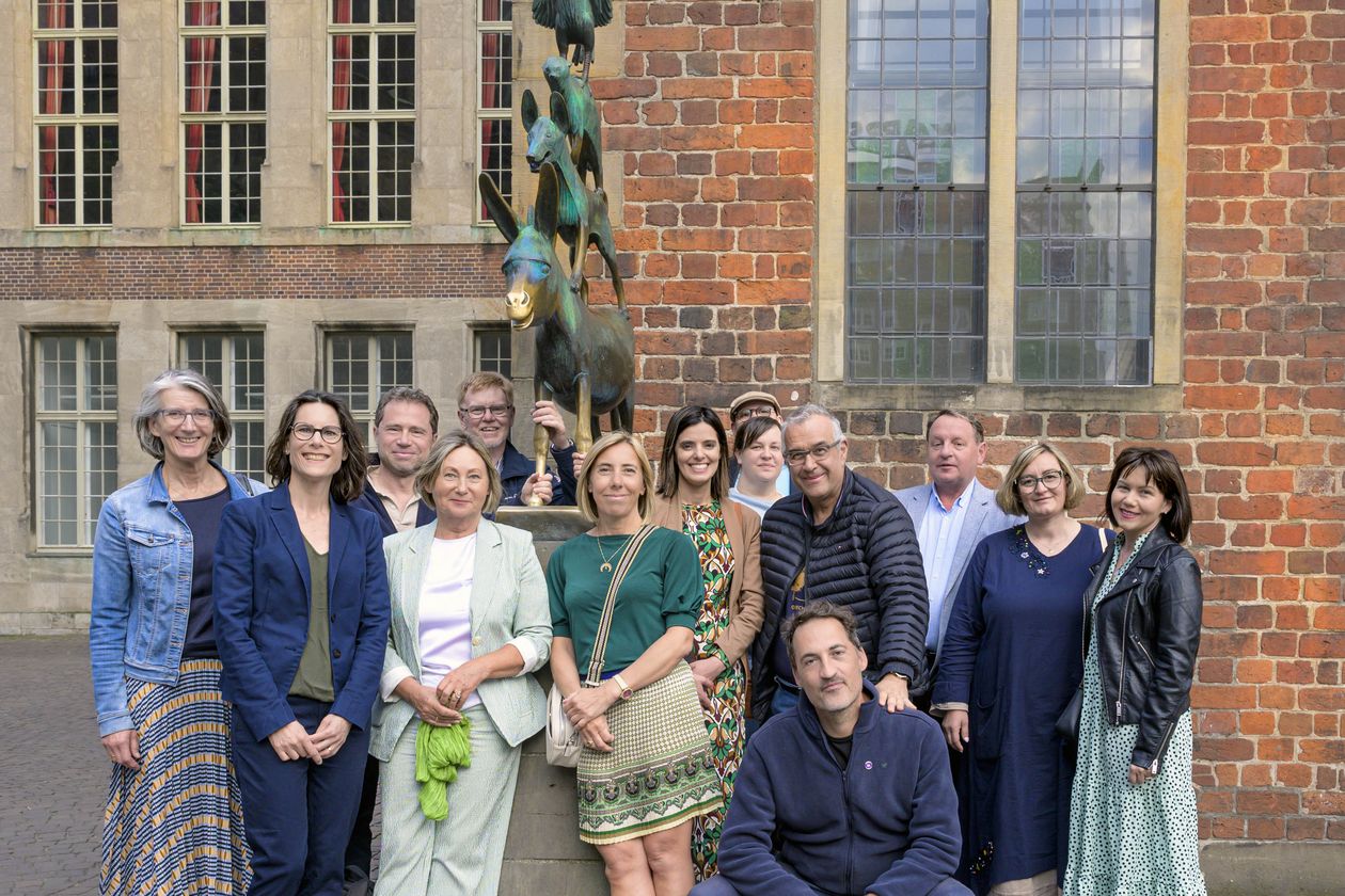 Group of women and men at the sculpture of the Bremen Town Musicians