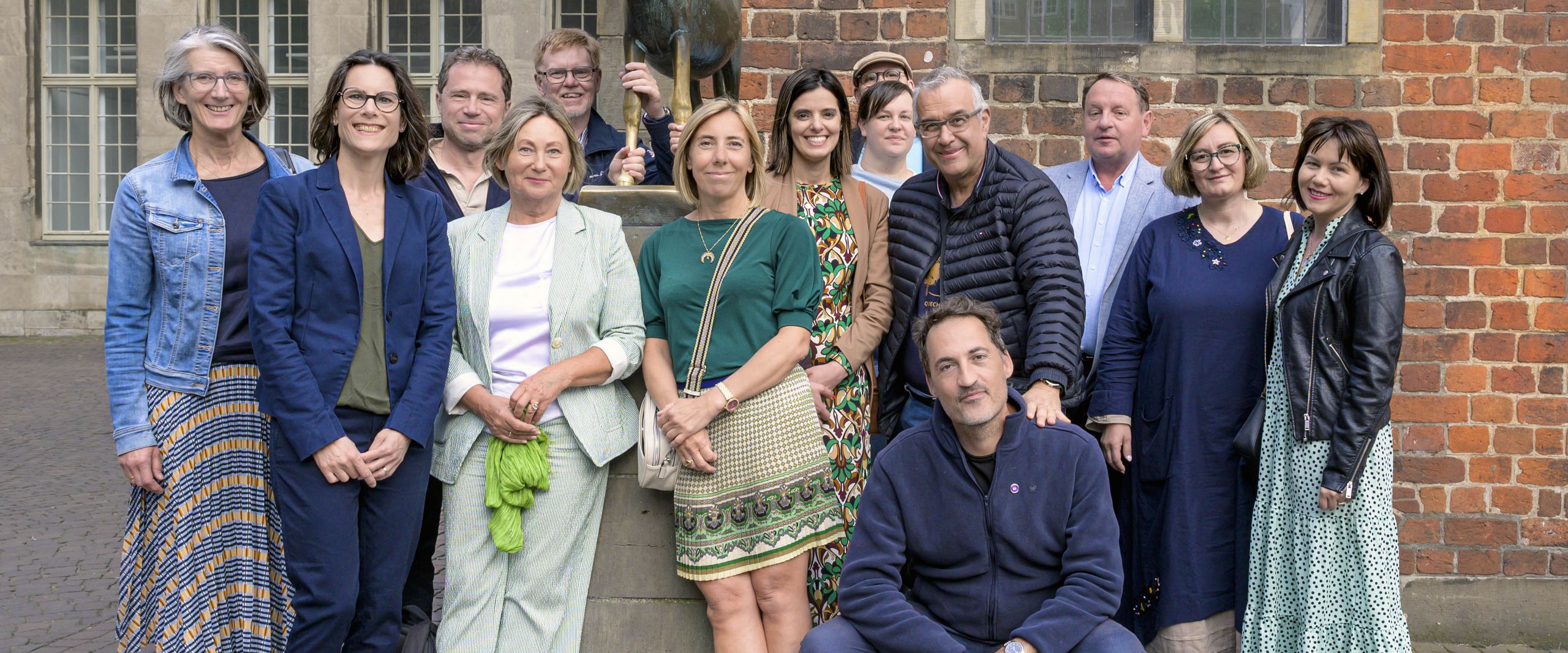 Group of women and men at the sculpture of the Bremen Town Musicians