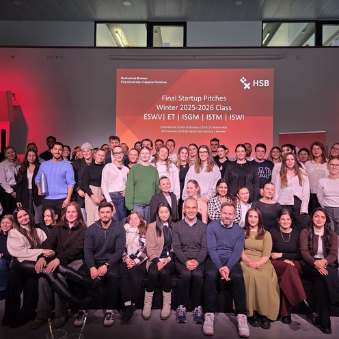 Gruppenbild mit circa 60 Personen, mehrheitlich Studierende mit der JUry und Dozenten. Im Hintergrund eine Präsentation mit der Aufschrift "Finale Startup PItches"