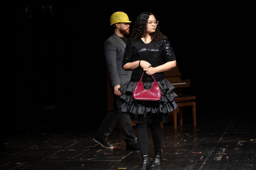 Frau mit Tasche steht auf der B&uuml;hne