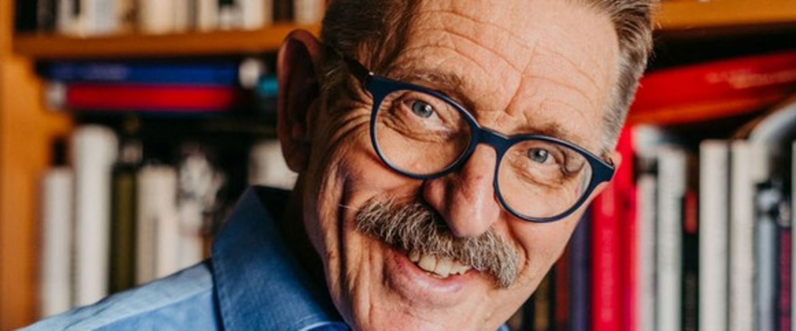 Das Bild zeigt Prof. Dr. Joachim Freimuth l&auml;chelnd vor einem B&uuml;cherregal.