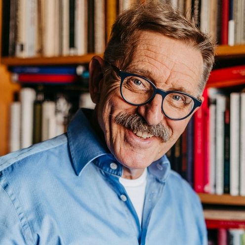 Das Bild zeigt Prof. Dr. Joachim Freimuth l&auml;chelnd vor einem B&uuml;cherregal.