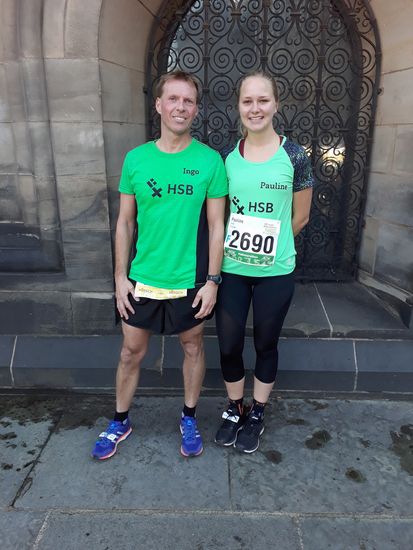 Zwei Läufer stehen vor einem Gebäude.