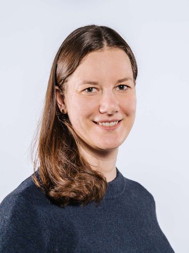 Auf dem Bild ist Jessica Brüggebors zusehen. Sie hat schulterlanges, braunes Haar und trägt einen dunkelblauen Pullover. 