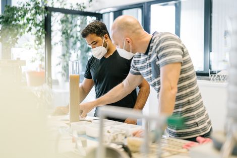 Ein Professor zeigt einem Studenten etwas an einem Experiment im Geotechniklabor.