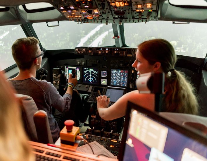 Flugsimulator Studierende sitzen im Cockpit eines realistischen Flugsimulators.