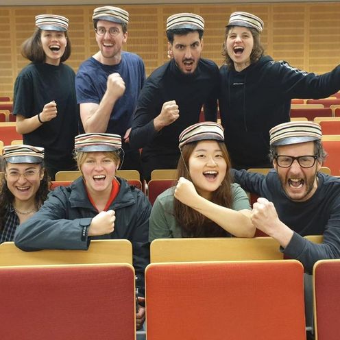 Gruppenbild mit jungen Menschen, die jubeln.