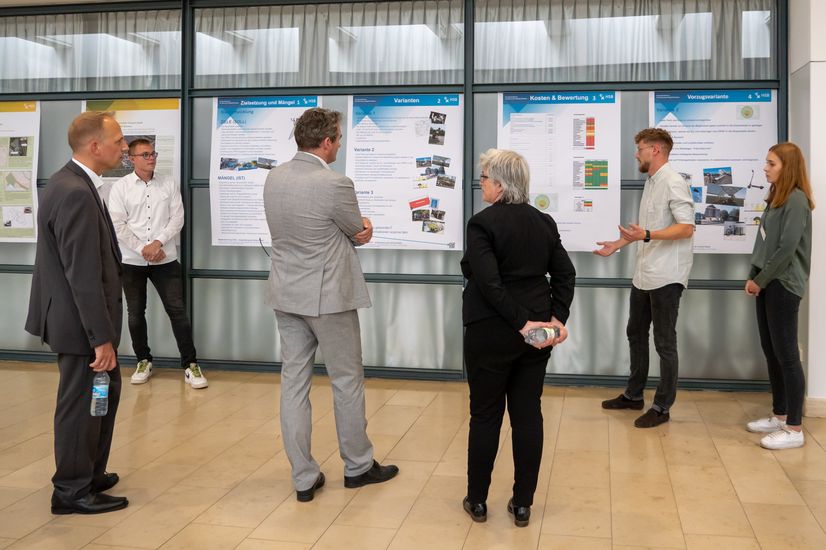 Studierende präsentieren dem Publikum ihre Konzepte auf Postern am Bremer Flughafen.