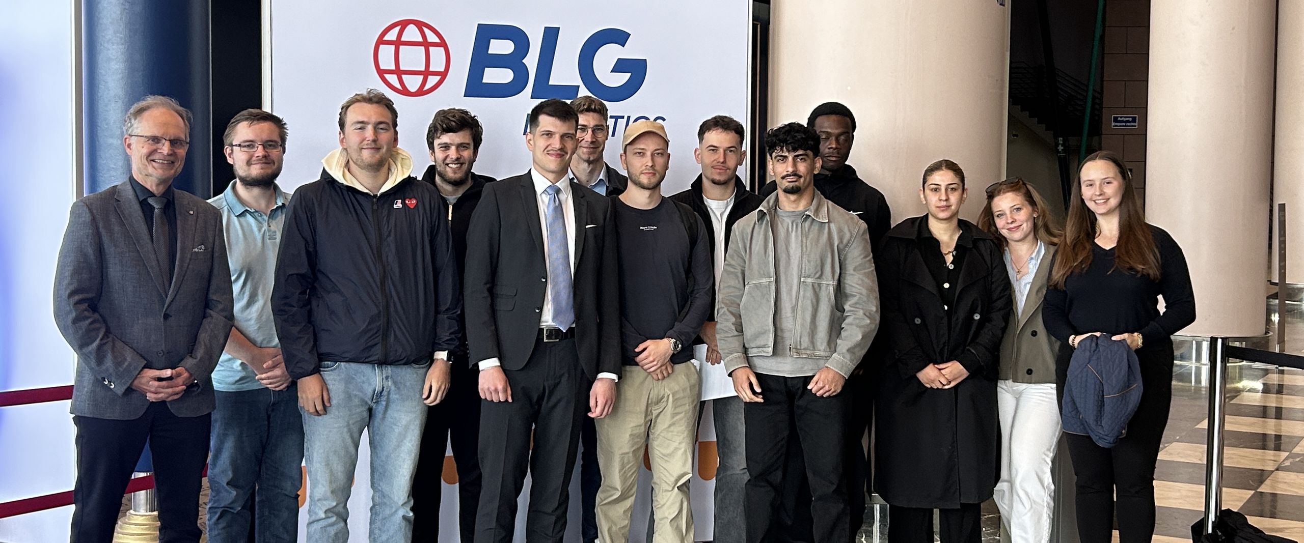 Besuch bei der Hauptversammlung der BLG Das Bild zeigt Prof. Dr. Schlemminger und Studierende vor dem Logo der BLG.