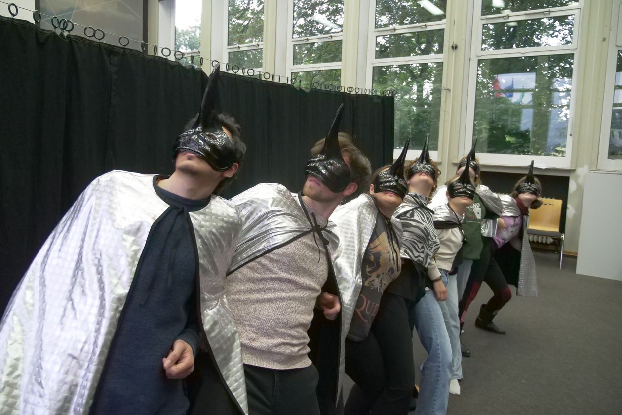 Menschen tanzen mit Volgelmasken