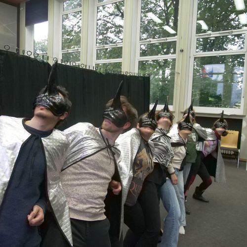 Menschen tanzen mit Volgelmasken