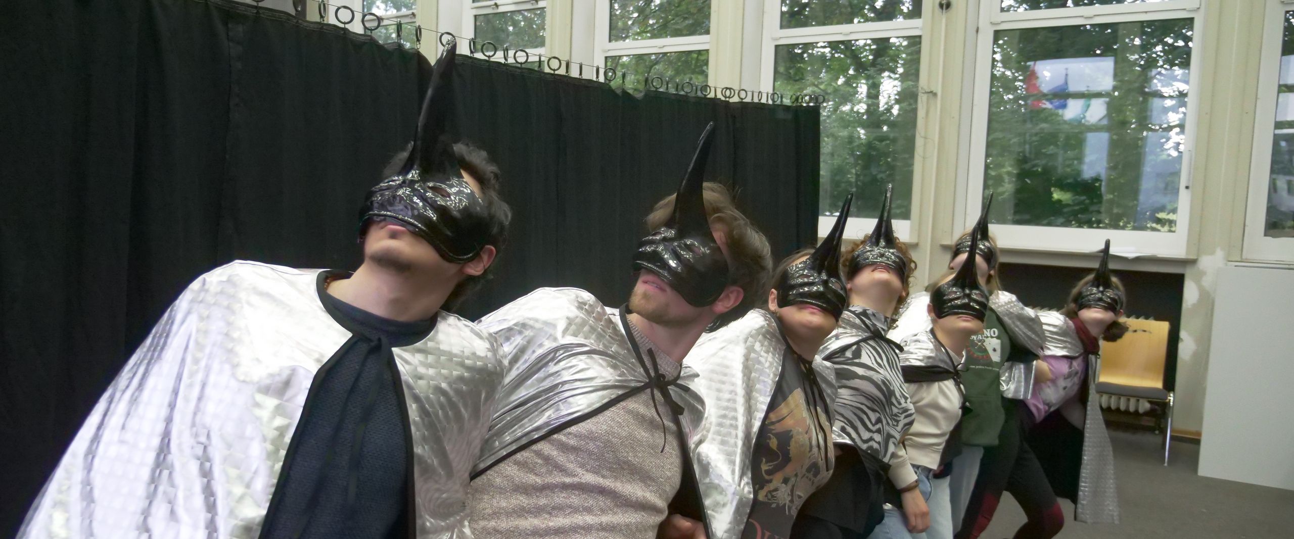 Menschen tanzen mit Volgelmasken