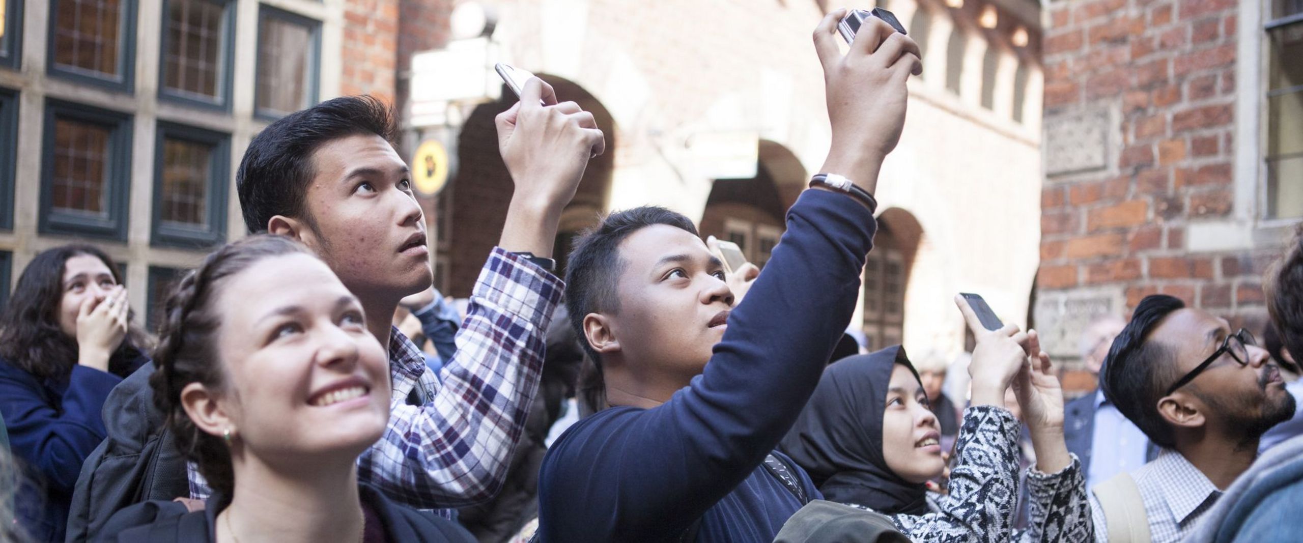 Austauschstudierende machen Fotos bei einer Stadtführung.