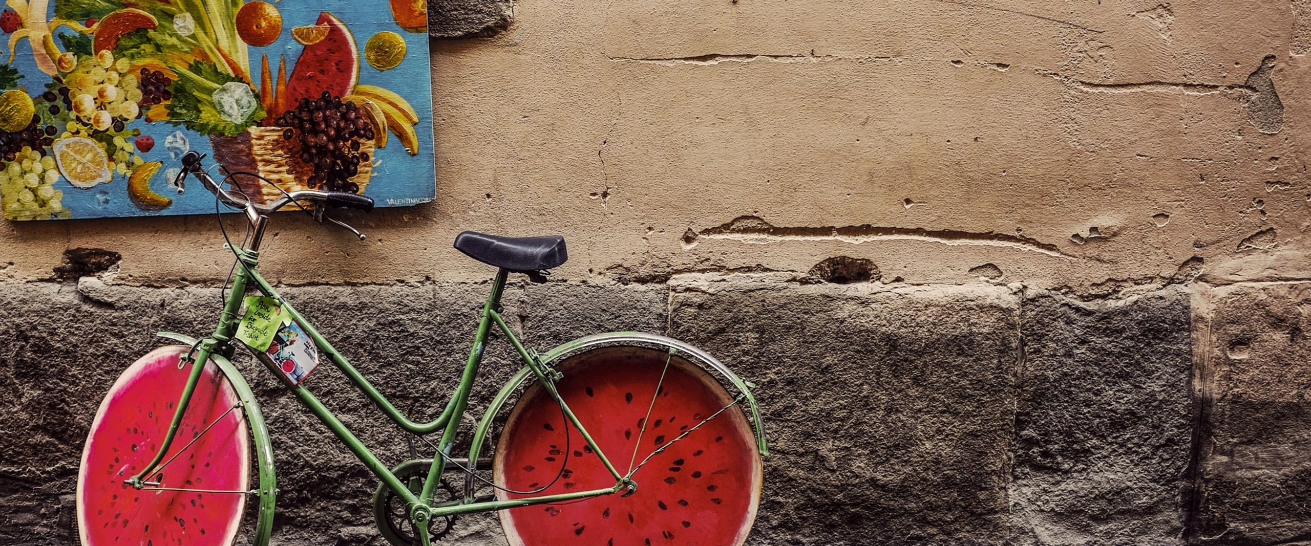 Grünes Fahrrad vor Wand mit Obstmotiven