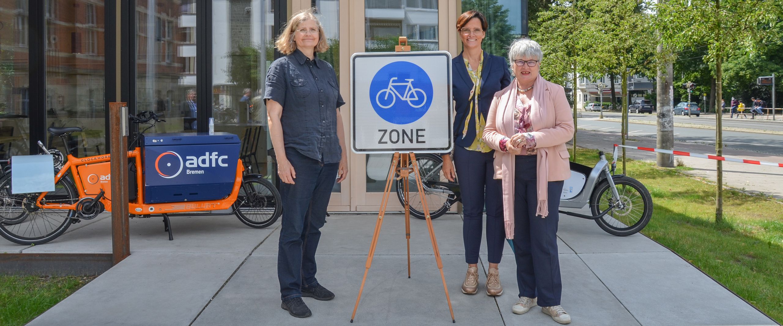 Fahrrad-Repaircafé Steffi Kollmann, Ulrike Mansfeld und Karin Luckey stehen neben einem Schild "Fahrradzone" vor dem FahrradRepaircafé.