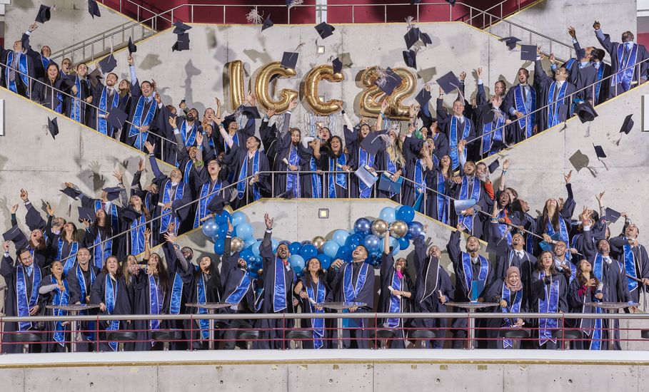 Absolvent:innen des International Graduate Centers stehen in Talare gekleidet auf der Treppe des Bremer Metropol Theaters und werfen ihre Hüte in die Luft.