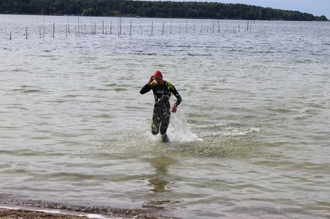 Ein Schwimmer kommt aus dem Wasser.