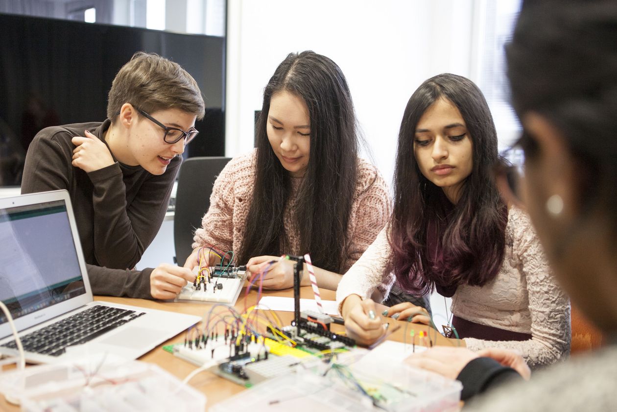 Drei jungen Frauen arbeiten an einem Tisch.
