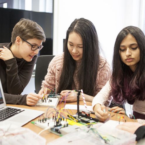 Illu MINT-Tag Bremen Drei jungen Frauen arbeiten an einem Tisch.