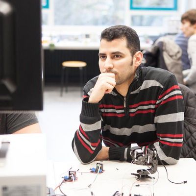 Student concentrating on a computer screen during an electronics lab session.
