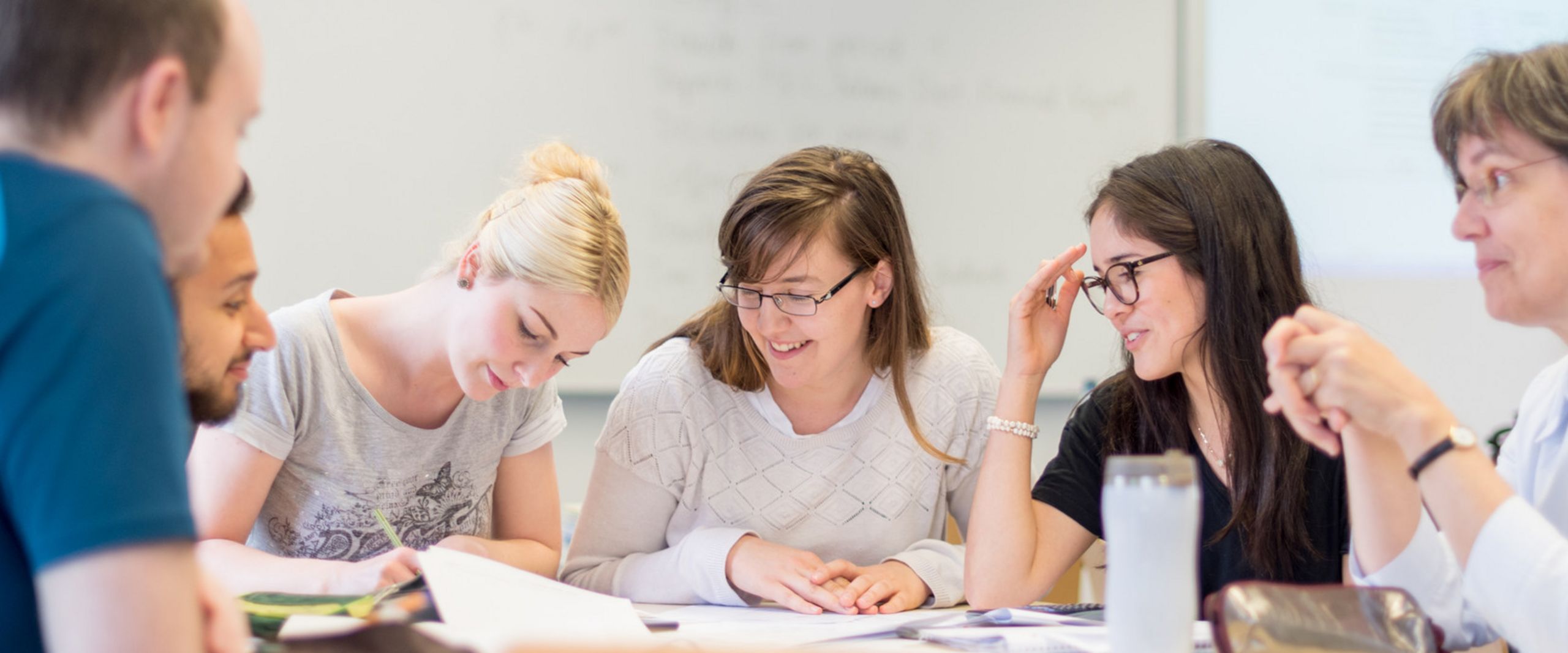 Prof.Dr. Martina R&ouml;hrich sitzt mit einer kleinen Gruppe Studierender an einem Tisch