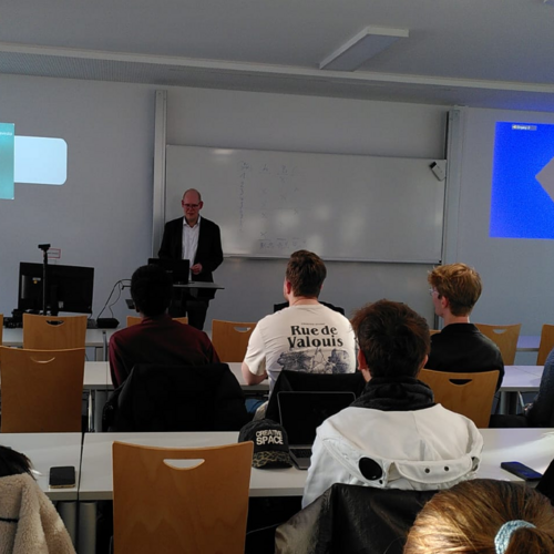 Das Bild zeigt eine Gruppe Studierender und den Gastredner Benedikt Limberg.