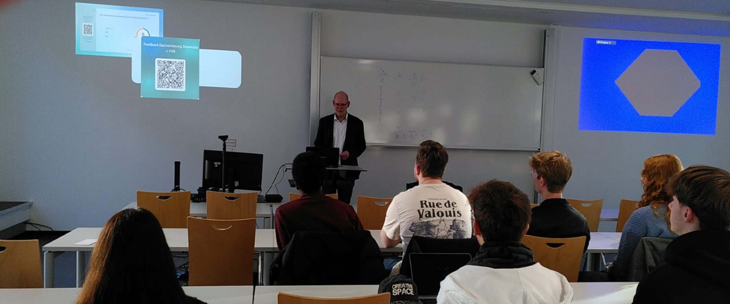 Das Bild zeigt eine Gruppe Studierender und den Gastredner Benedikt Limberg.