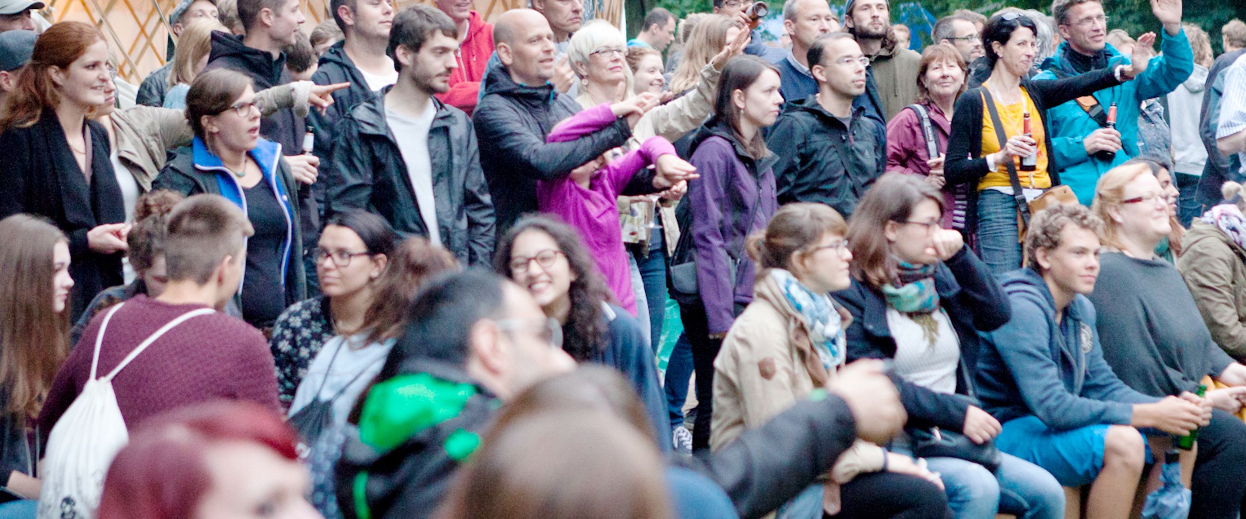Eine Publikumsgruppe schaut gespannt auf etwas au&szlig;erhalb des Bildes.