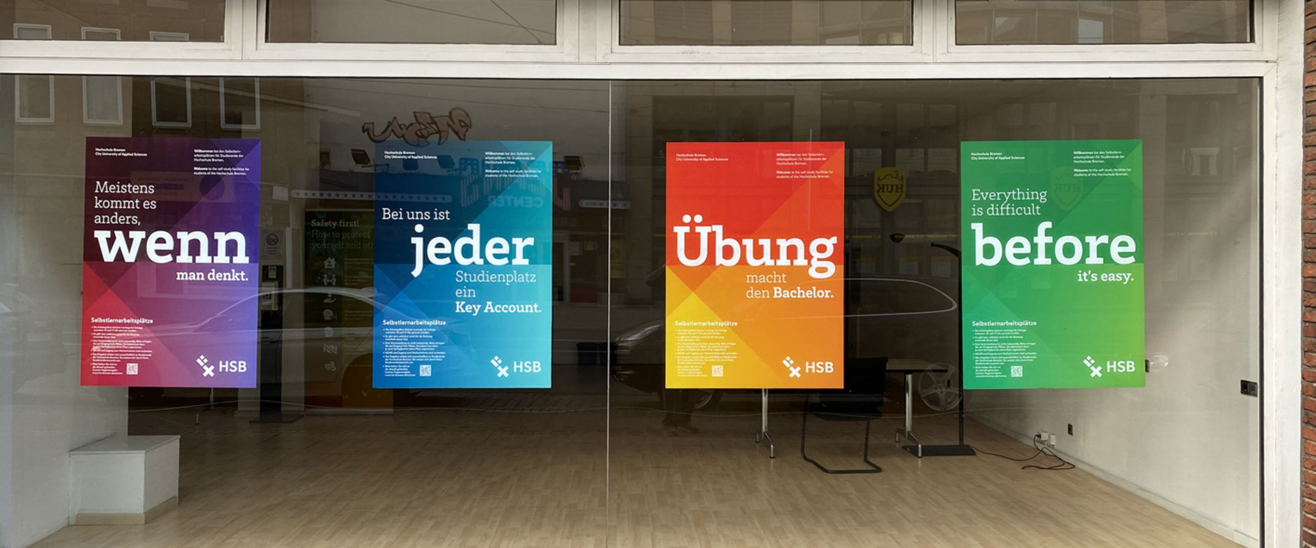 Bunte Plakate an leerstehendem Gesch&auml;ftsraum