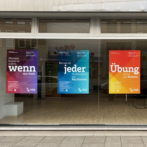 Bunte Plakate an leerstehendem Gesch&auml;ftsraum