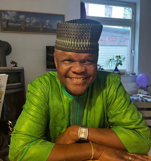 Portrait eines Mannes, der in die Kamera lacht.