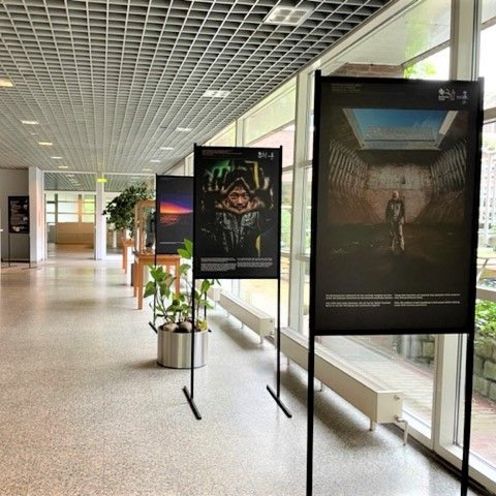 Raum mit Aufstellern, auf denen gro&szlig;formatige Fotos zu sehen sind.