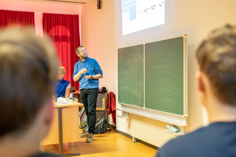 Prof. Dr. Stefan Veltel beim Vortrag "Mit KI gegen Bakterien?" vor einer Schulklasse