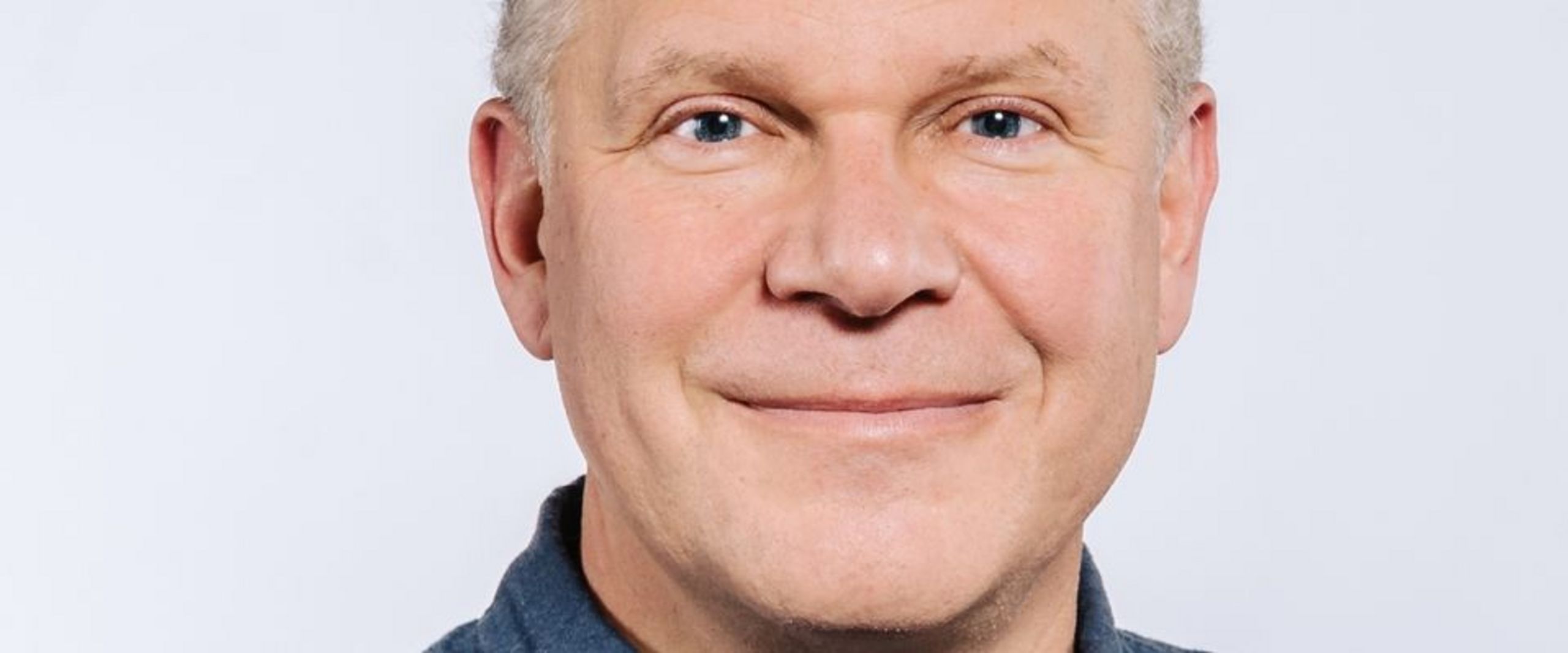 Auf dem Bild ist Christian Spatscheck zu sehen. Er hat kurzes braunes Haar und trägt ein blaues Hemd. 