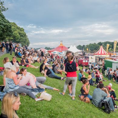 Osterdeich bei der Breminale mit vielen Zelten und Menschen, die auf der Wiese sitzen und stehen