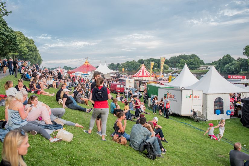 Osterdeich bei der Breminale mit vielen Zelten und Menschen, die auf der Wiese sitzen und stehen